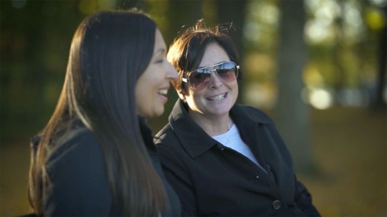 Megan Torres and her mother, Michelle, share a laugh on a park bench.